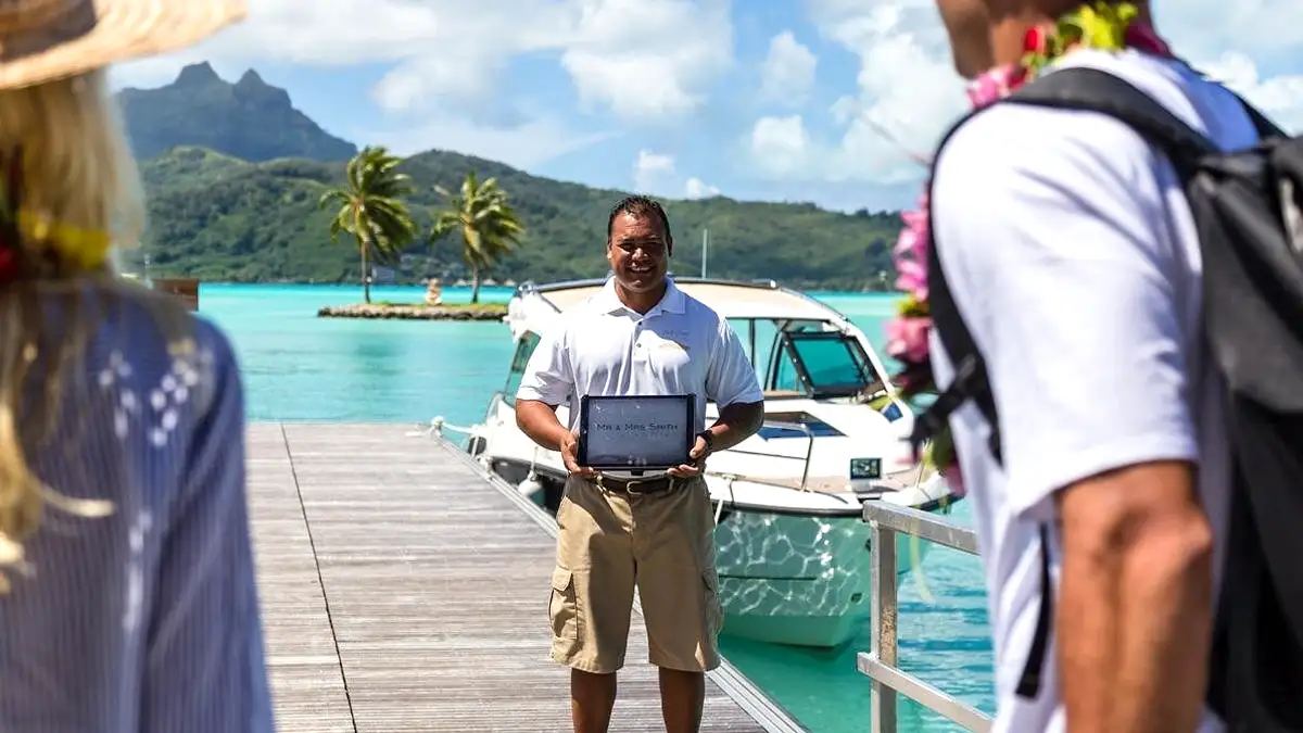 Bora Bora airport pickup with private captain holding a name sign