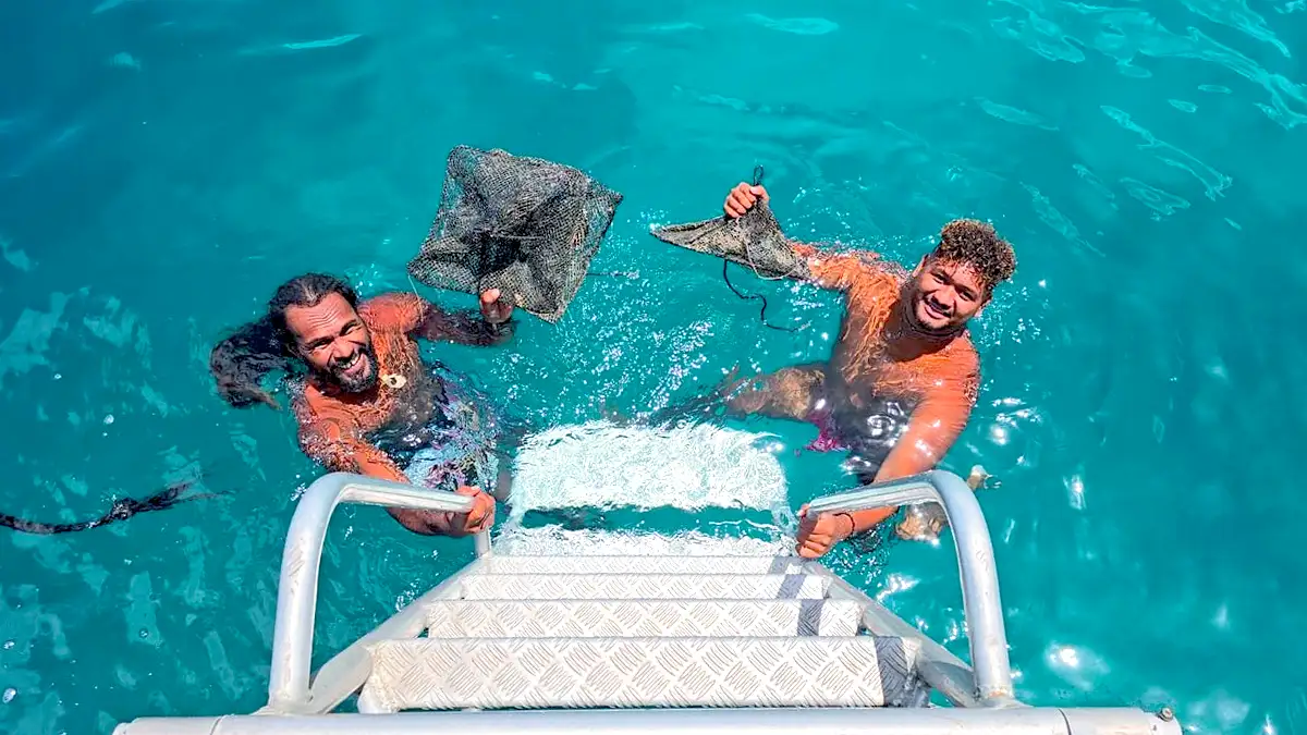 Tour guides collecting the oysters during a Pearl Farming Tour In Bora Bora