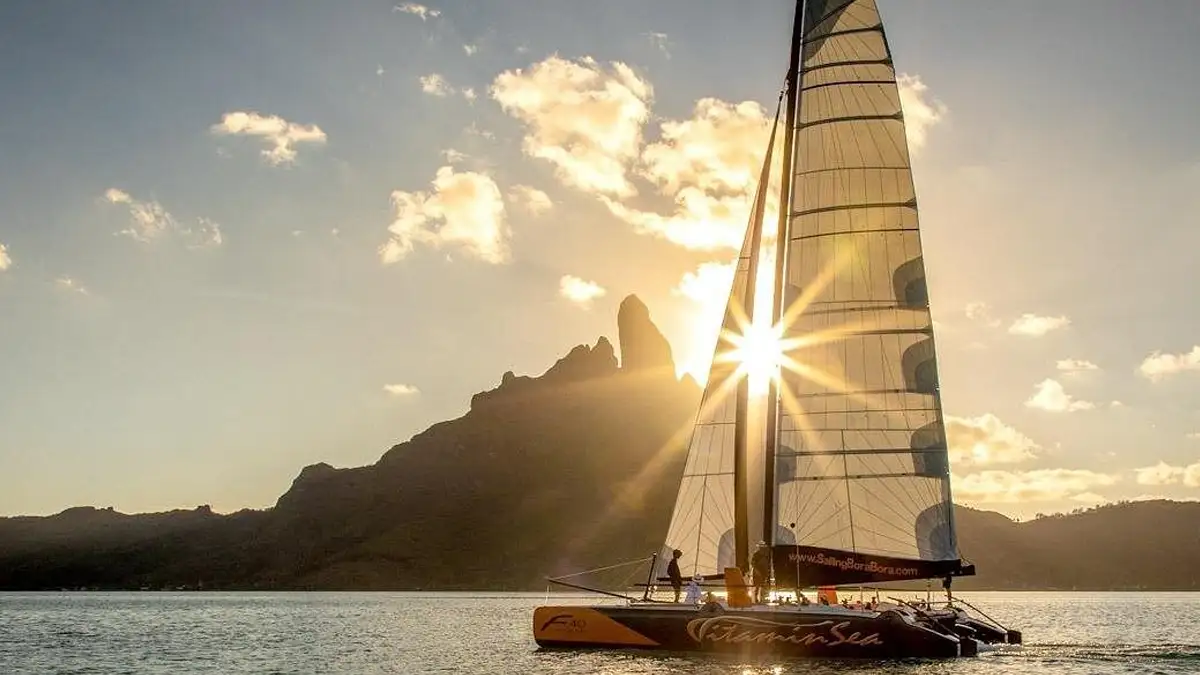 Sport catamaran during sunset in Bora Bora in front of Mount Otemanu